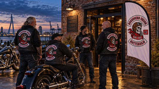 A Custom Flag That Represents Your Motorcycle Club Story: custom motorcycle club feather flag shown in veteran chapter founders outside a weathered brick clubhouse at blue hour with unbranded American V-twin motorcycles.