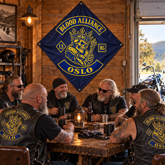 Six riders relax after a ride beneath a custom diamond flag in a warm timber motorcycle clubhouse.