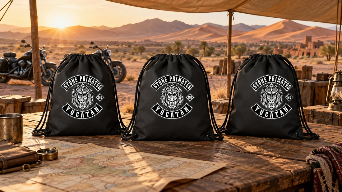 Stone Primates Yucatan motorcycle club drawstring bags arranged on a fixed-HQ gear custody table in a desert rally setting