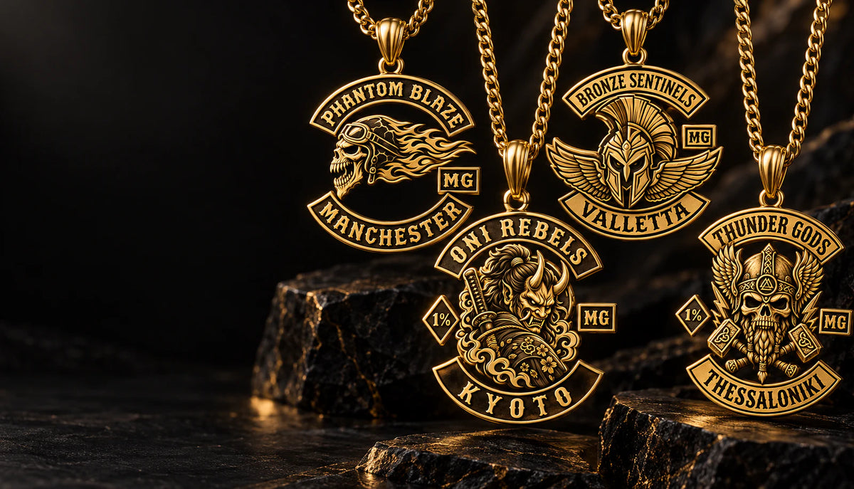 Four solid 18K gold motorcycle club pendant concepts with complete chains in a dark jewelry atelier.