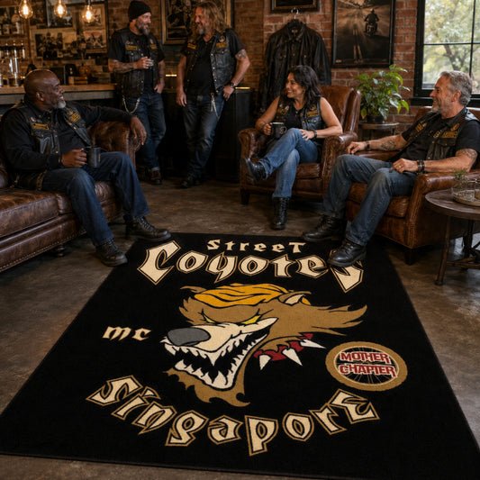Motorcycle club members gather around a custom logo rug in a clubhouse lounge.