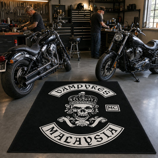 A custom motorcycle club rug sits beside American V-twin motorcycles in a workshop.