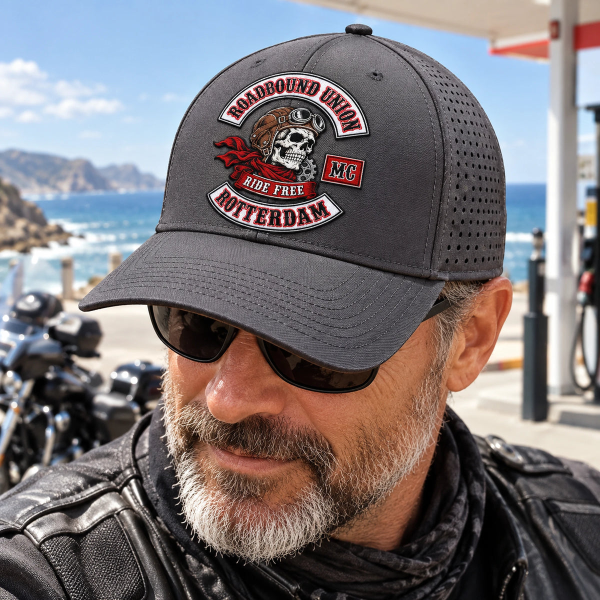 ライダーが、湾曲したつばと公認ロゴの付いたグラファイト製パフォーマンスモーターサイクルクラブキャップを着用しています。