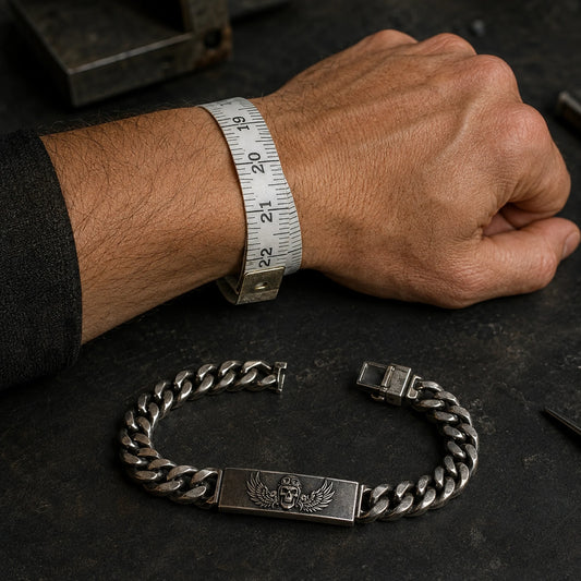 Flexible tape measures a bare wrist beside an open Bikers Kental silver ID chain bracelet