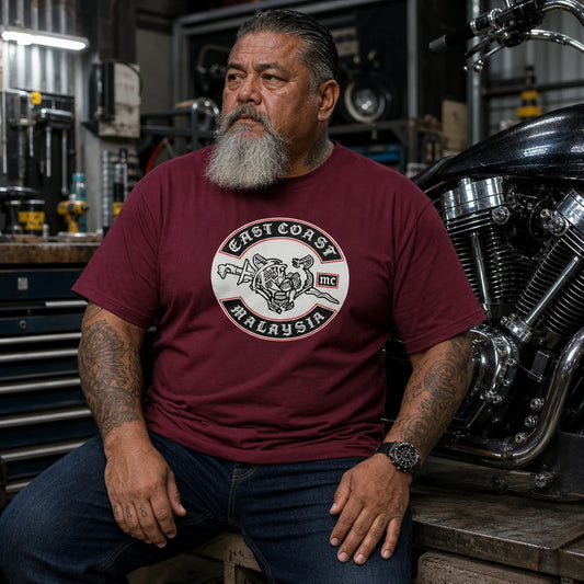 East Coast MC Malaysia member wearing a structured burgundy heavyweight cotton motorcycle club T-shirt in a V-twin workshop.
