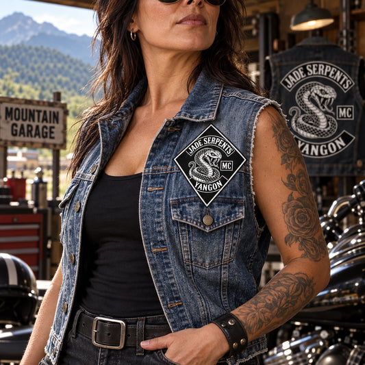Woman rider wearing a red and black chapter diamond patch on a denim vest at a mountain garage.