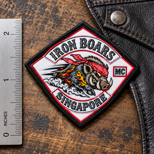 Compact embroidered diamond patch measured beside a ruler on a leather vest panel for a motorcycle club.