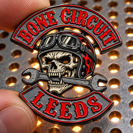 BONE CIRCUIT motorcycle club pin with real open cut-outs visible over a backlit workshop surface.