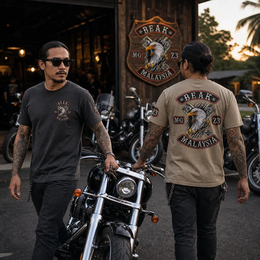 BEAK MG riders showing a small left-chest emblem and large full-back club logo while moving a V-twin motorcycle outside their clubhouse.