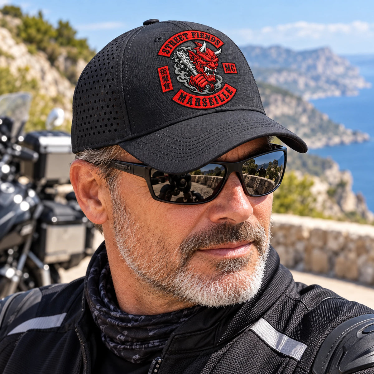ライダーは、通気性やテクニカルファブリックのディテールが施されたEight Demonsモーターサイクルクラブのパフォーマンスキャップを着用しています。