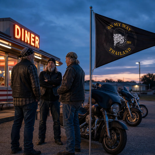 Heritage-cruiser riders display a custom motorcycle club triangle flag outside a roadside diner at blue hour.