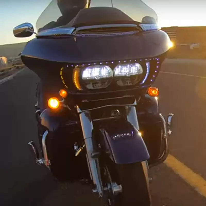 Harley Road Glide riding with illuminated white and amber headlight outline LEDs