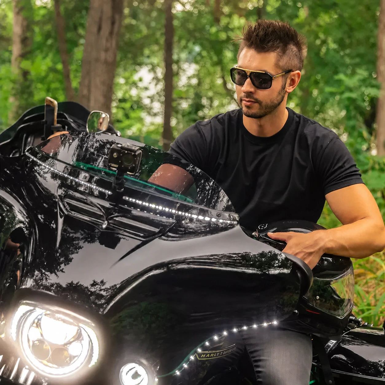 Harley touring motorcycle with illuminated LED windshield trim in an outdoor riding setting