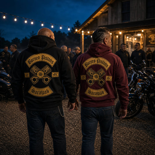 Two members wear square-framed anniversary motorcycle club hoodies with milestone back embroidery at a nighttime gathering.