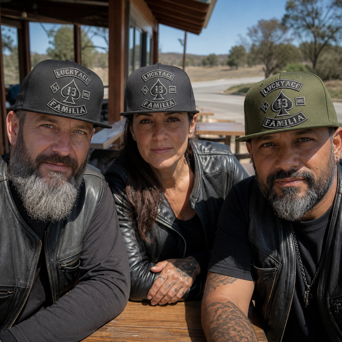 Motorcycle club members wear matching custom flat-brim caps during a relaxed road-stop gathering.