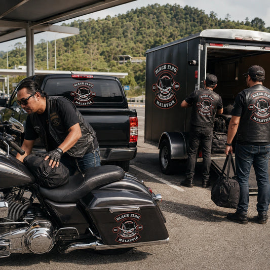Motorcycle road crew using matching club stickers on a V-twin pannier, support pickup and enclosed trailer.