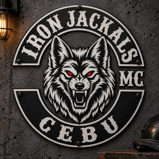 Matte-black motorcycle club metal sign on a dark industrial clubhouse wall.
