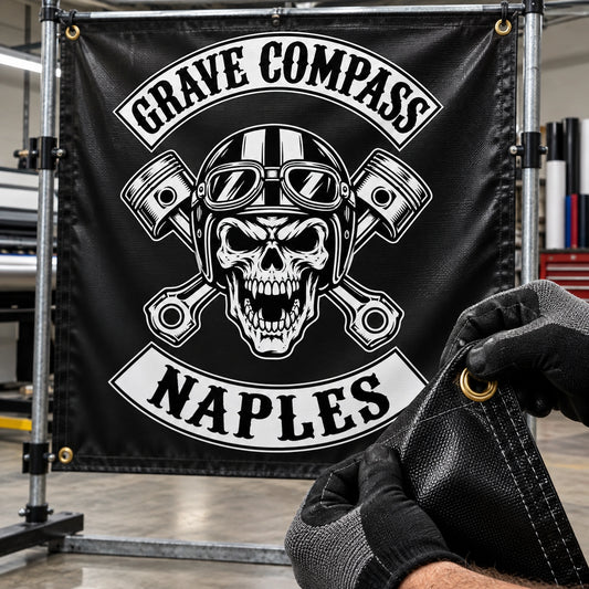 Event crew securing a heavy-duty custom motorcycle club banner at a windy coastal rally.