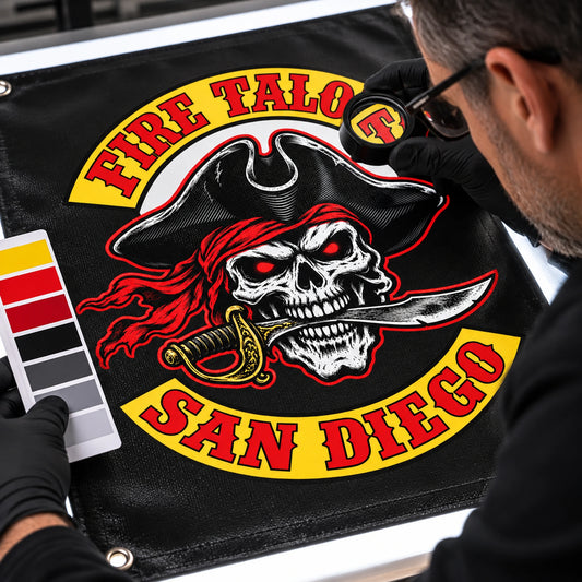 A quality inspector examining sharp logo detail on a custom motorcycle club banner.