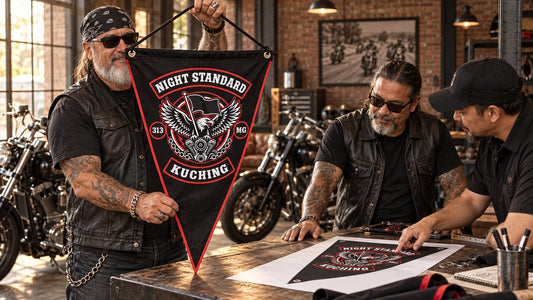 Mature motorcycle club riders review a finished custom triangle flag with a designer inside their clubhouse workshop.