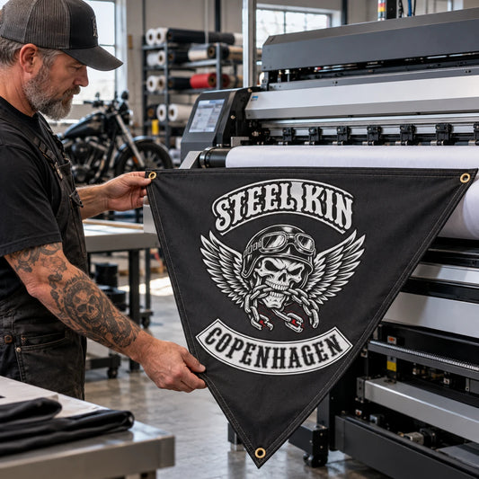 A print operator checks detailed club artwork during production of a custom triangle flag.