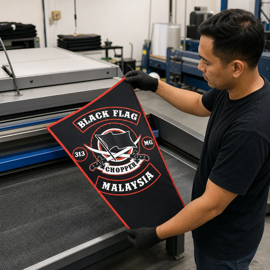 A print operator checks detailed club artwork during production of a custom triangle flag.