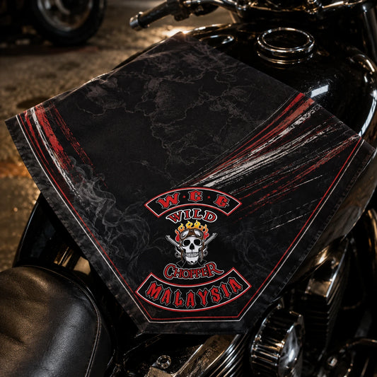 Custom motorcycle club bandana featuring the authorized Wild Chopper Mg identity in bandana folded diagonally on a motorcycle tank so the corner emblem remains visible.