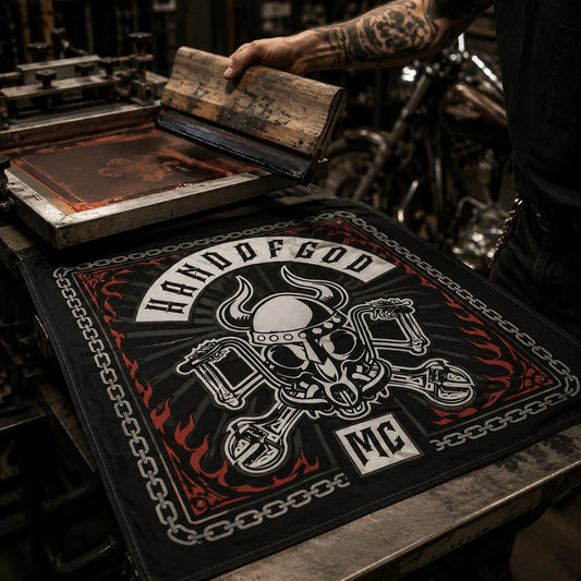 Custom motorcycle club bandana featuring the authorized Hand of God Custom Cycles identity in authentic screen-print station, squeegee lifted from a bold freshly printed bandana.