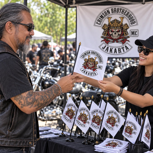 A motorcycle club member chooses collectible custom hand flags at a rally merchandise booth.