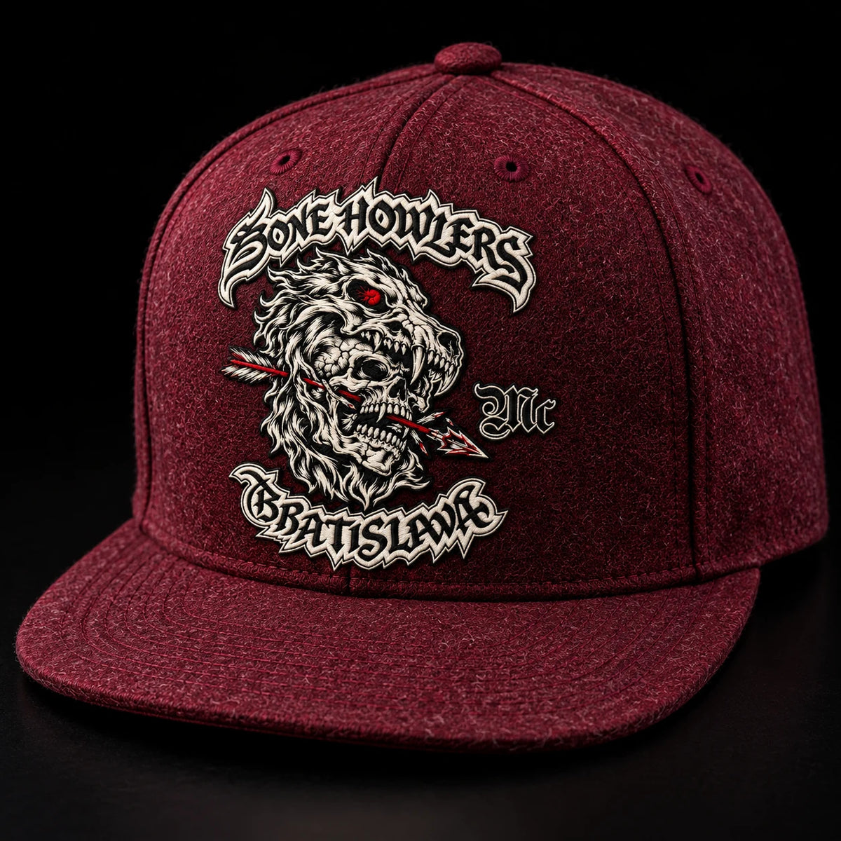 Una gorra de visera plana granate de un club de motociclistas exhibe una textura densa gracias a su mezcla de acrílico y lana.
