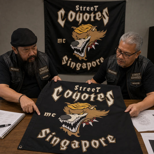 A professional designer builds a custom motorcycle club flag layout at a calibrated workstation.
