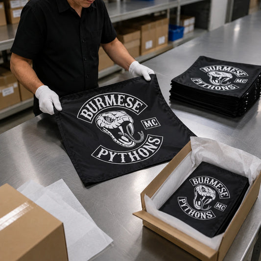 Finished custom motorcycle club flags move from final inspection to protective packing for shipment.