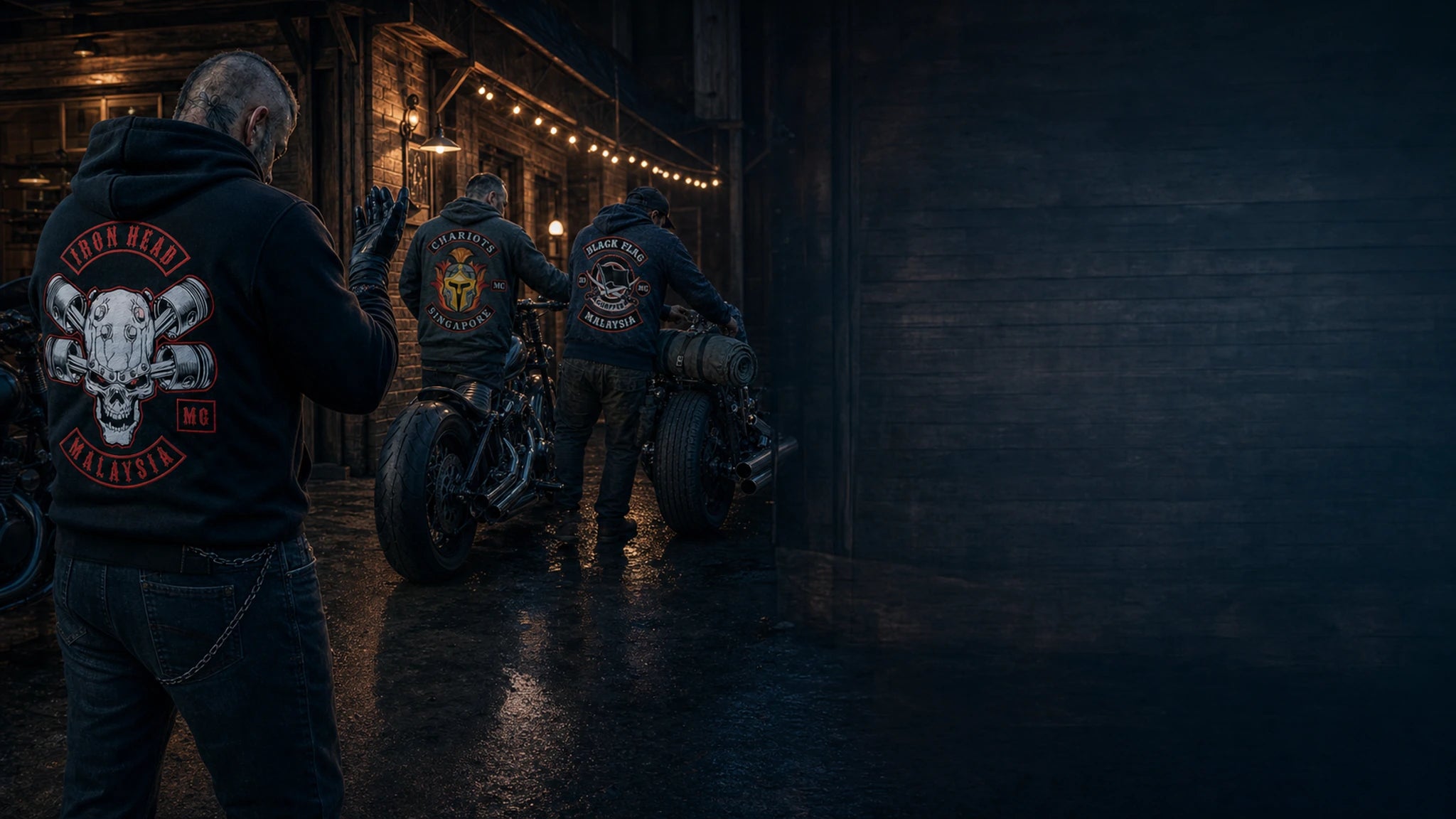 Three motorcycle club members wearing custom logo hoodies prepare V-twin motorcycles outside a clubhouse at blue hour