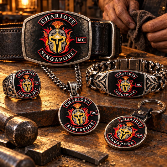Custom motorcycle club jewelry and metal gear engraved with an authorized club logo on an artisan workbench.