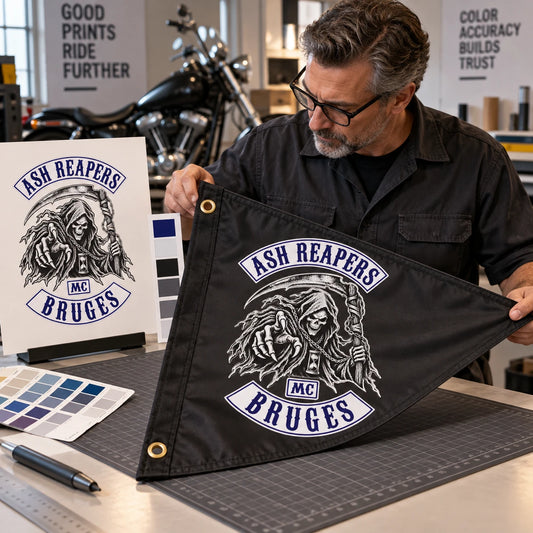 A print technician compares approved motorcycle club artwork with the finished custom triangle flag.