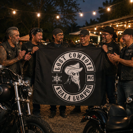 Adult club members celebrate a milestone together with a custom emblem flag at an outdoor evening event.