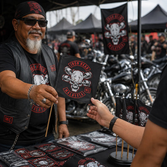 A motorcycle club member chooses a collectible custom flag from a rally merchandise table.