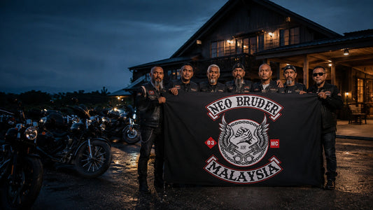 A motorcycle club crew holds its custom rally flag beside American V-twin cruisers before a blue-hour clubhouse ride.
