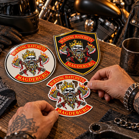 Designer arranging round, shield and contour-cut motorcycle club sticker samples around an authorized club logo.