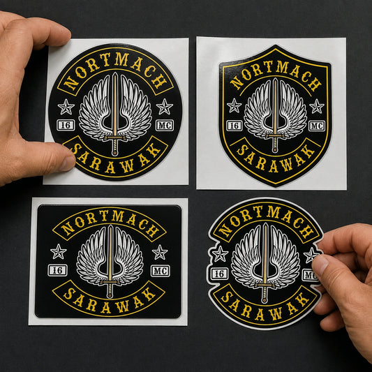Designer arranging round, shield and contour-cut motorcycle club sticker samples around an authorized club logo.