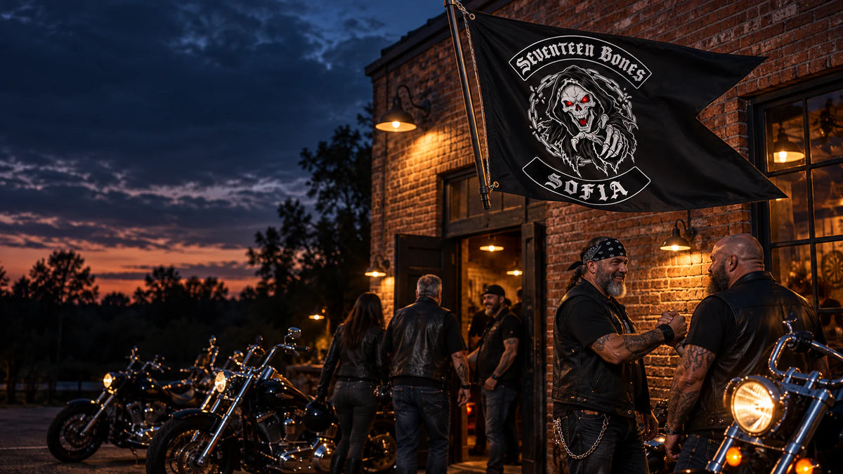 Motorcycle club riders outside a brick clubhouse beneath a custom swallowtail flag for a motorcycle club.
