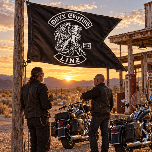 Mature cruiser riders with a classic custom swallowtail flag at a desert fuel stop for a motorcycle club.