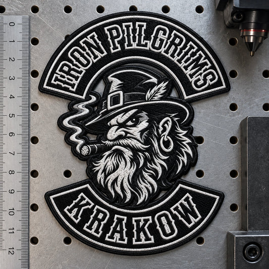 Irregular original winged mechanical emblem patch for a motorcycle club, shown at laser-cutting inspection surface.
