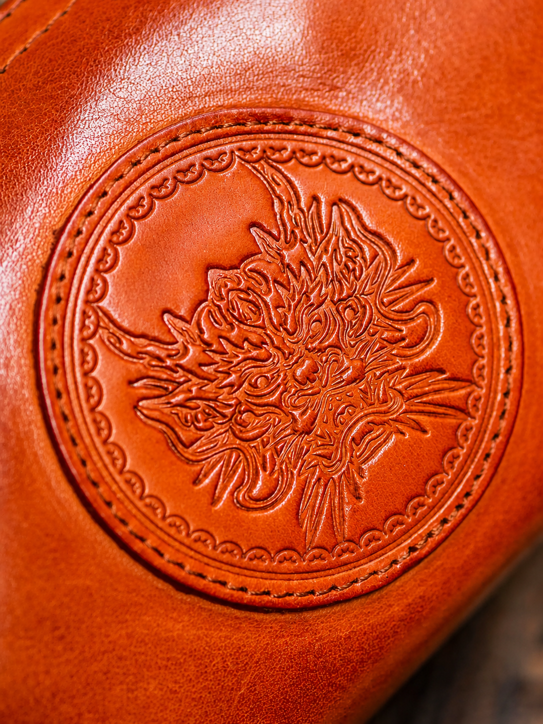 close-up of decorative dragon medallion on top-grain leather wallet