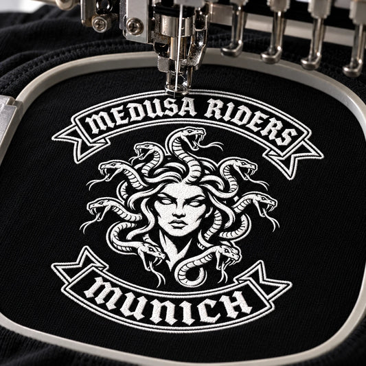 Compact motorcycle club chest emblem being embroidered onto a premium long-sleeve shirt.