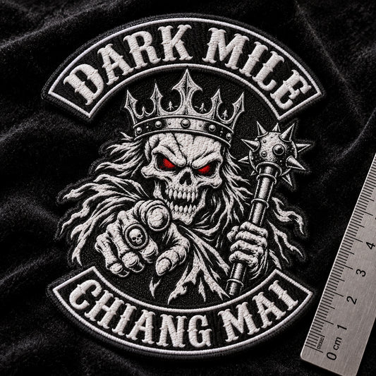 Dense flat-embroidered club chest patch for a motorcycle club, shown at black velvet macro stage.