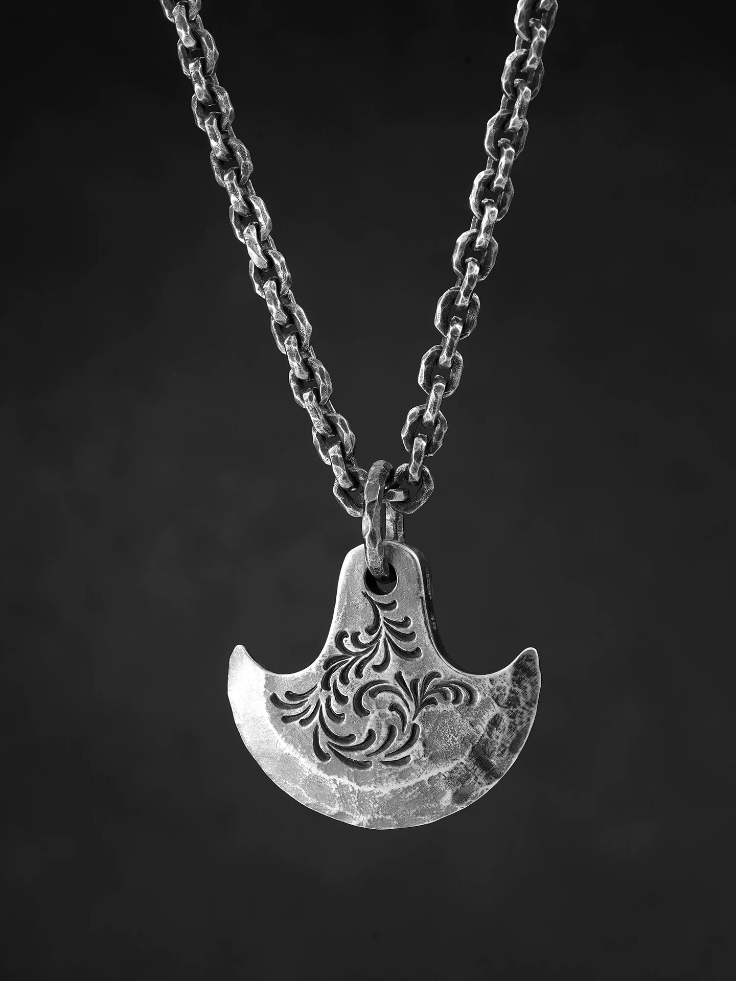 Engraved axe sterling silver pendant displayed on chain