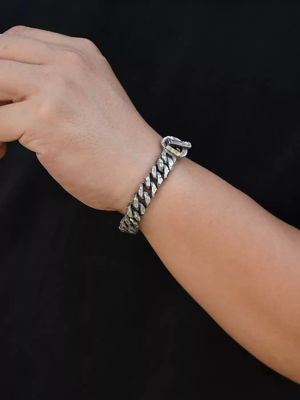 men's engraved silver Cuban link bracelet worn on wrist