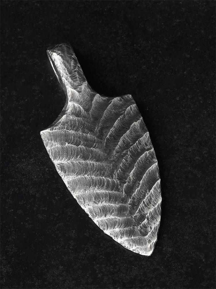 Hand-hammered arrowhead silver pendant angled view