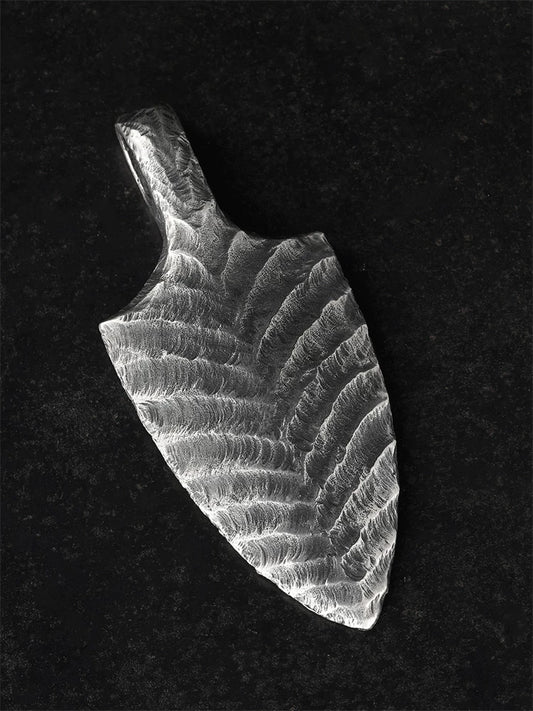 Hand-hammered arrowhead silver pendant angled view